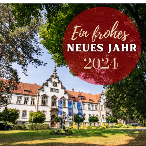 Abbildung des Verwaltungsgebäudes der LWL-Klinik Warstein, darüber der Text "Ein frohes neues Jahr 2024".
