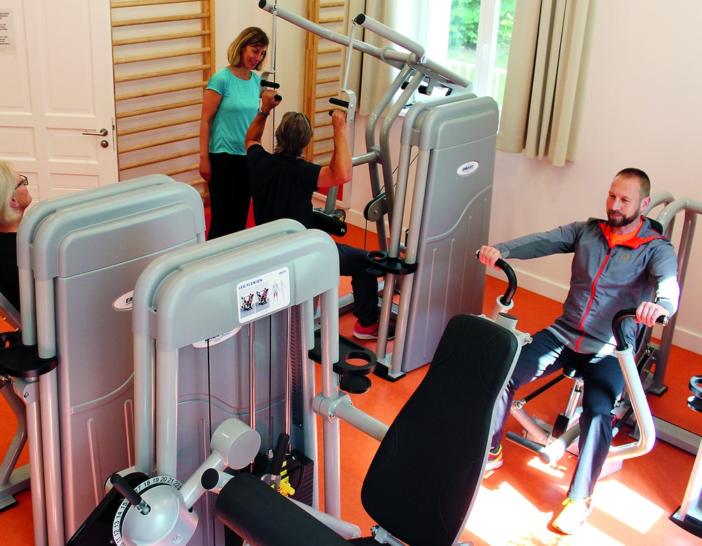 Drei Personen trainieren im Fitnessbereich der Sucht Reha